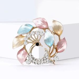 Détail de l'élégante broche paon avec pétales en émail coloré et strass blancs