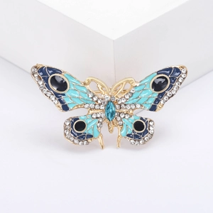 Broche papillon dorée avec émail bleu et strass brillants pour une touche élégante