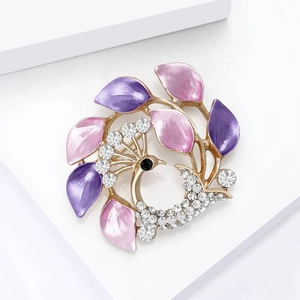 Détail d'une broche paon avec pétales en émail rose et strass blancs étincelants
