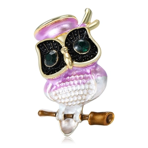 Vintage owl brooch with black glasses and green gemstone eyes on white background
