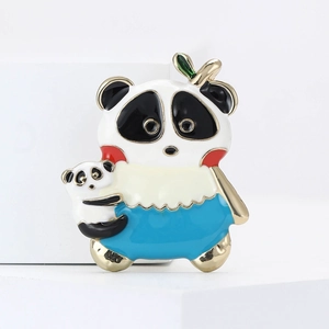 Vue détaillée d'une broche panda en émail et plaqué or sur un présentoir géométrique