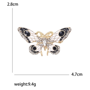 Élégante broche papillon en émail noir et blanc avec strass mesurant 2,8 cm par 4,7 cm