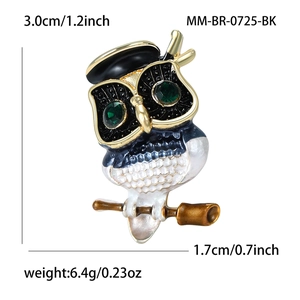 Vintage owl brooch with green gem eyes and black glasses on polished gold-tone branch