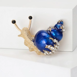 Detailed view of snail brooch with blue enamel shell and sparkling crystal rhinestones