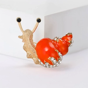 Macro shot of snail brooch detail with orange enamel shell and sparkling rhinestones