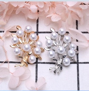 Detailed view of elegant gold and silver branch brooches with lustrous white pearls