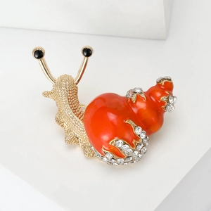 Charming gold-tone snail brooch with orange enamel and sparkling crystal rhinestones