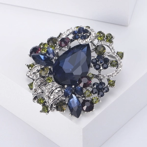 Makro-Detail der Vintage-Blumenbrosche mit tiefblauem Kristall und farbigen Strasssteinen
