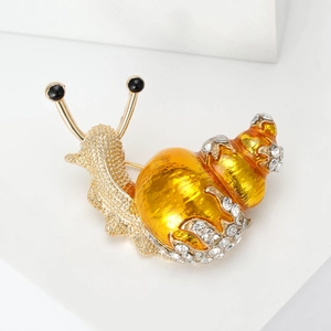 Detailed macro view of crystal snail brooch with gold plating and sparkling rhinestones