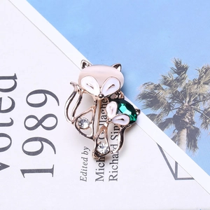 Vintage fox brooch with green gemstone and cat-eye stones on a golden base