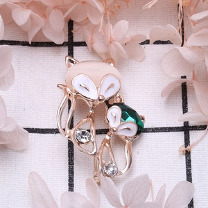 Vintage gold fox brooch with cat eye stone and crystals on a plaid background