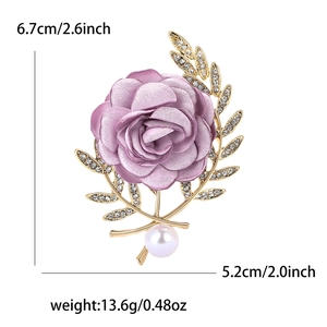 Macro de la broche rose en tissu violet avec feuilles dorées en cristal et perle