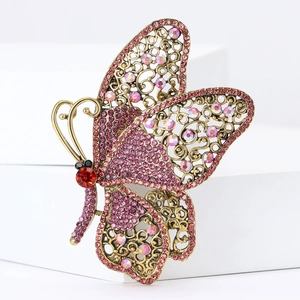 Close-up of vintage gold butterfly brooch with pink and purple crystal rhinestones
