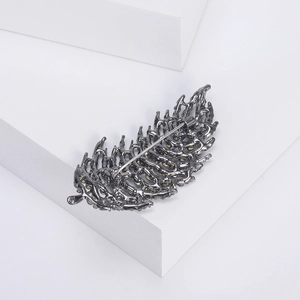 Back view of minimalist hollow feather brooch with gunmetal finish and secure rotating pin