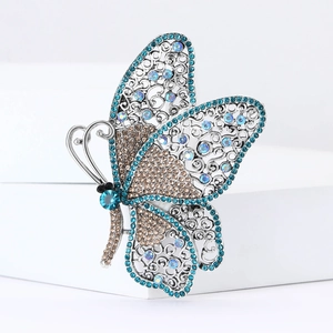 Close-up detail of silver alloy butterfly brooch with blue rhinestones and filigree mesh