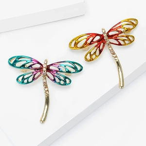 Enamel dragonfly brooches with gradient wings and sparkling rhinestones on a white stand