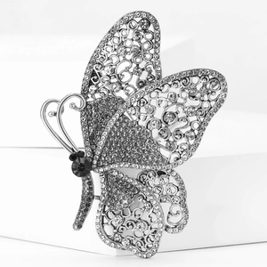 Detailed macro view of crystal butterfly brooch with silver hollow metalwork and black gemstone