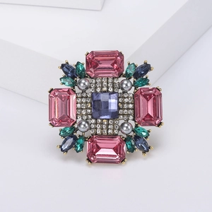 Détail d'une broche vintage en alliage avec pierres roses et bleues et petites perles