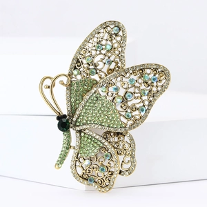 Vintage gold alloy butterfly brooch with green rhinestones and hollow wing design