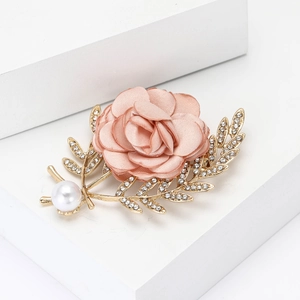 Élégante broche fleur en tissu rose avec base dorée et feuilles de strass brillants