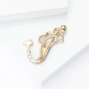 Detailed back view of golden mermaid brooch showing metal texture and pin fastener