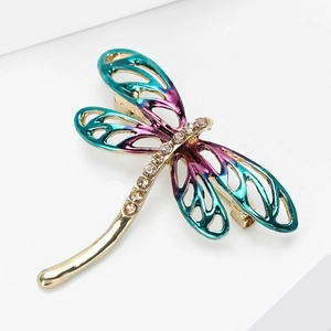 Detailed macro view of dragonfly brooch with colorful enamel wings and crystal inlay