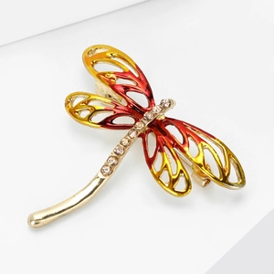 Detail view of dragonfly brooch with red-yellow gradient wings and crystal rhinestones