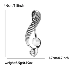 Detail showing musical G-clef brooch with dimensions 4.6cm by 1.7cm and pearl accent