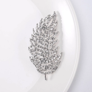 Macro detail of leaf brooch featuring silver plating and shimmering clear crystal stones