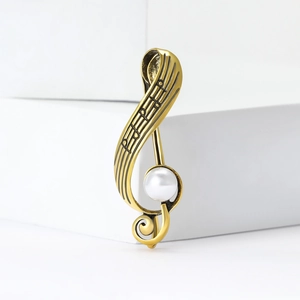 Retro musical note brooch in gold alloy featuring a central pearl on minimalist blocks
