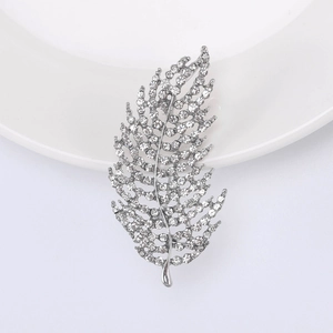 Detailed view of feather leaf brooch with sparkling crystals and silver metal finish