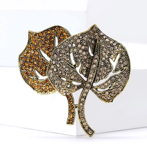 Detailed view of vintage monstera leaf brooch with amber and champagne crystals