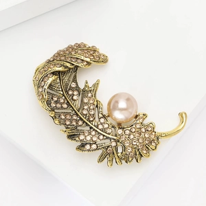 Broche plume vintage dorée avec strass champagne et perle rose élégante