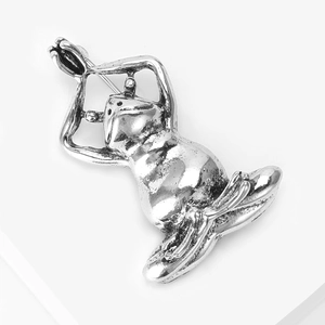 Detail view of vintage silver frog yoga brooch with textured alloy finish and back pin closure