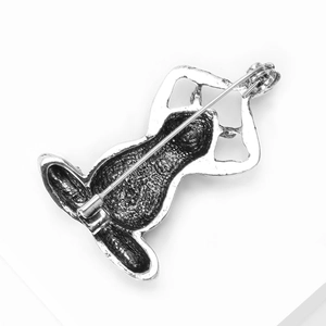 Detail view of vintage silver yoga pose brooch showing secure pin closure on the back side
