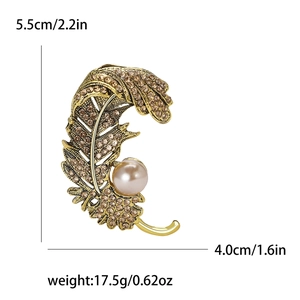 Broche plume dorée avec cristaux bruns et perle, dimensions 5,5 cm par 4,0 cm