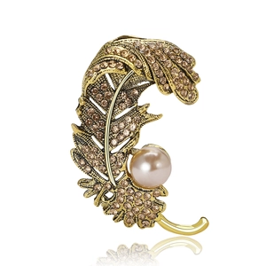 Broche plume dorée ornée de strass champagne et d'une perle rose pour femmes