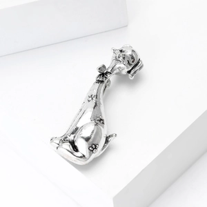 Detalle del broche de cachorro de plata vintage con lazo y patrón de huella de pata
