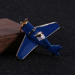 Macro shot of retro dark blue enamel airplane brooch with golden metal propellers