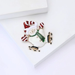 Broche bonhomme de neige en émail avec patins à glace et bonnet de Noël festif