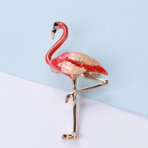 Detail of flamingo brooch with red enamel glaze and champagne wings on elegant background