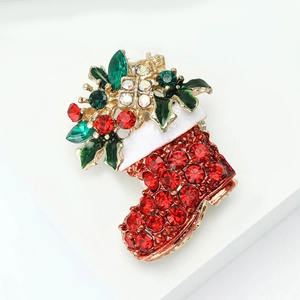 Christmas stocking brooch with red rhinestones and white enamel on a clean white background