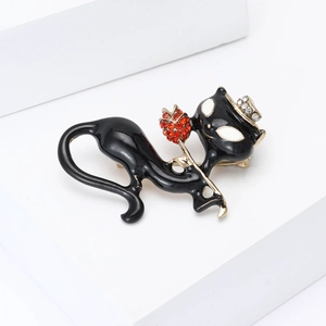 Détail d'une broche chat en émail noir avec fleurs en cristal rouge et couronne