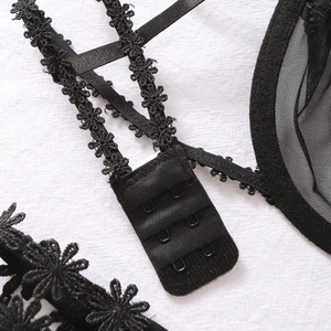 Detail of black lace lingerie showing 3-row hook closure and floral embroidery