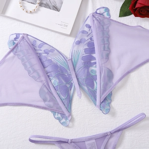 Detail of purple butterfly embroidery lingerie set on white fabric with roses