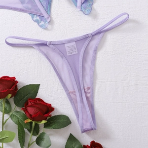 Close-up of purple mesh thong with delicate floral lace embroidery and laundry tag detail