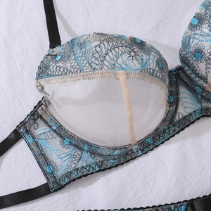 Dettaglio del ricamo floreale blu su un set di lingerie in rete nera trasparente
