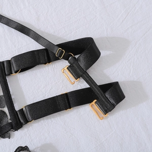 Detail of adjustable black elastic straps and premium gold metal hardware on lingerie set