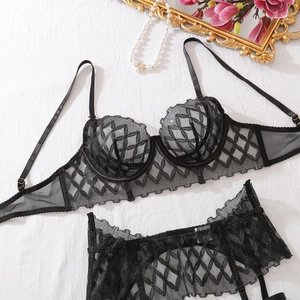 Flat lay of black lace lingerie set with mesh fabric and pearl jewelry detail