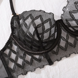 Close-up of black lace embroidery with floral mesh details and underwire structure